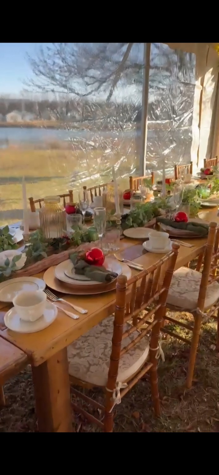 Christmas wedding reception table with greenery and red ornament favors