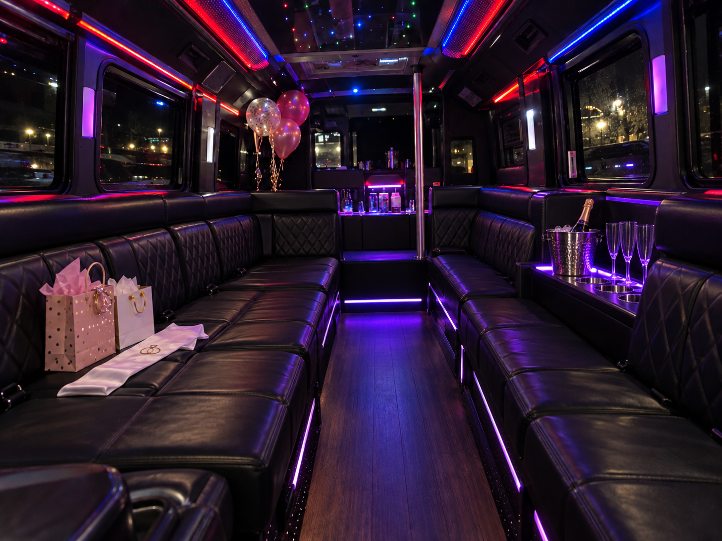 Party bus ready for a bridal party with colorful lights, champagne, gift bags, and black leather seating