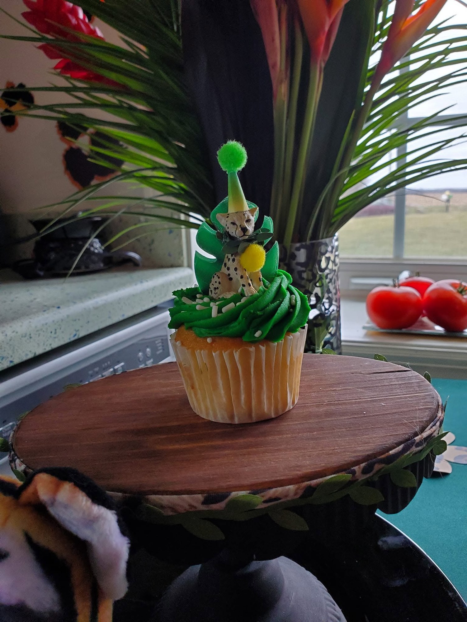 Tropical themed cupcake with green frosting and a party topper